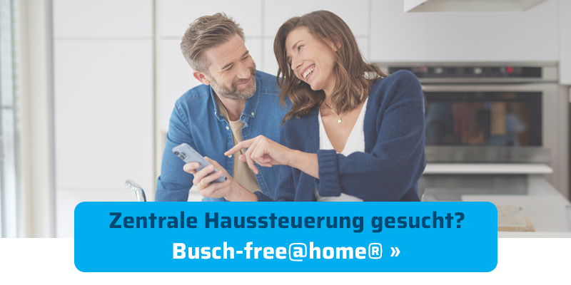 Ein lächelndes Paar in einer Küche bedient ein Smartphone. Blauer Button mit dem Text: „Zentrale Haussteuerung gesucht? Busch-free@home® »“.