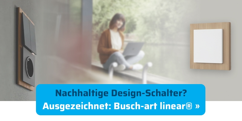 Nachhaltiger Design-Lichtschalter Busch-Jaeger Busch-art linear® mit Holzrahmen. Im Hintergrund sitzt eine Frau im Schneidersitz mit einem Laptop auf dem Schoß