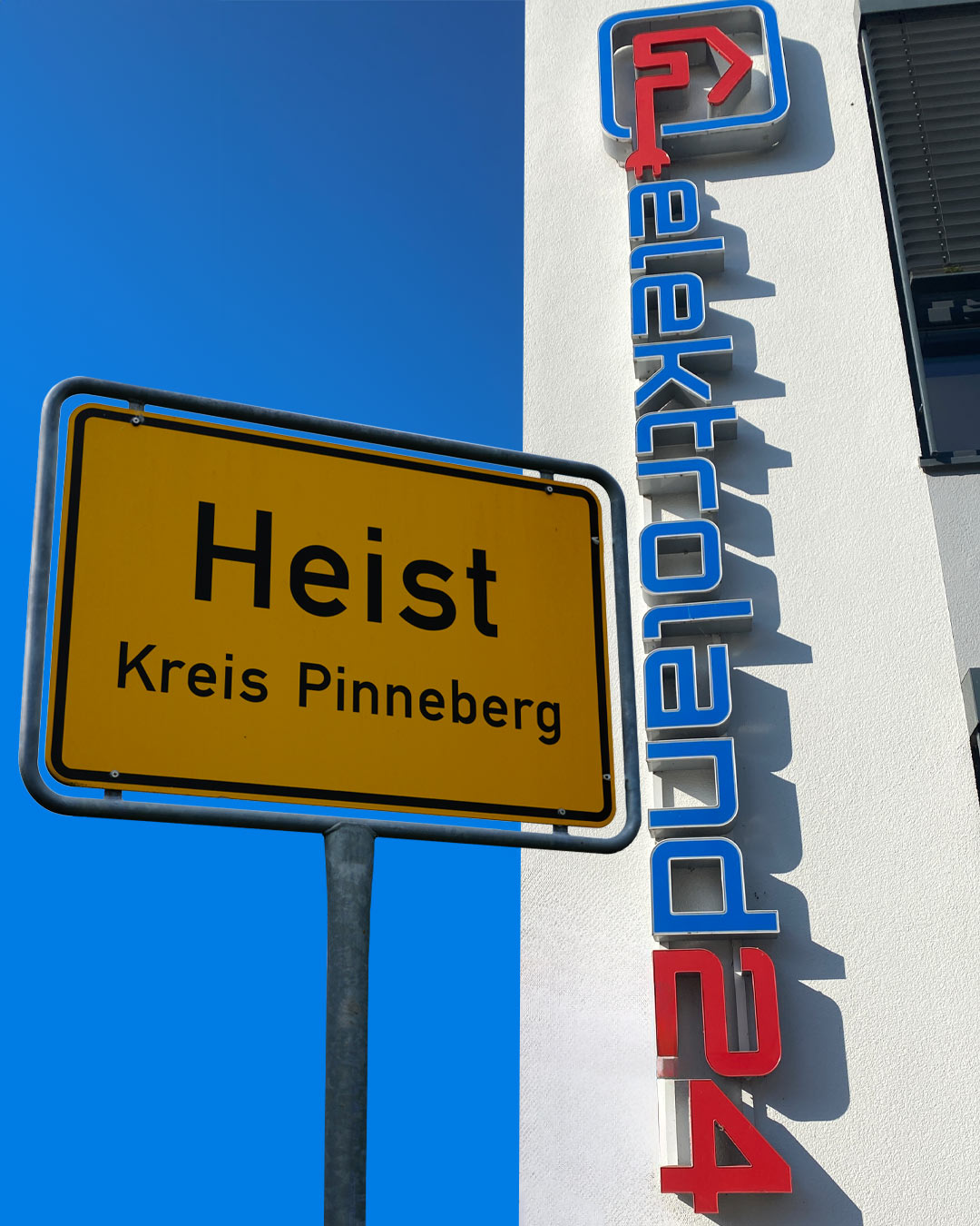Ortseingangsschild Heist und eine weiße Hauswand mit "elektroland24" Schriftzug senkrecht